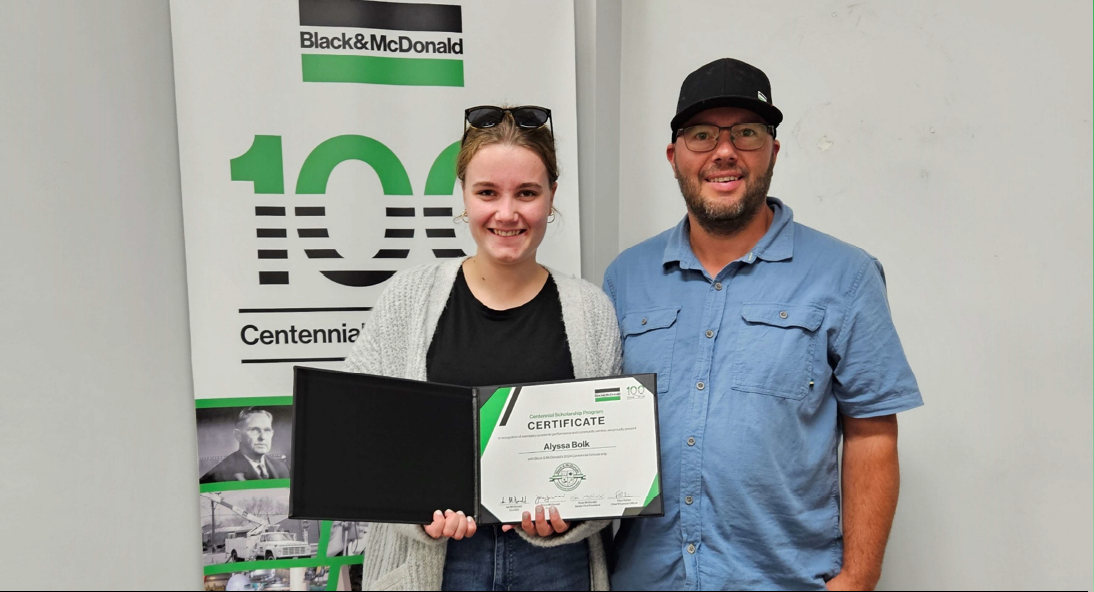 A scholarship recipient, and her father hold a certificate commemorating the Centennial Scholarships.